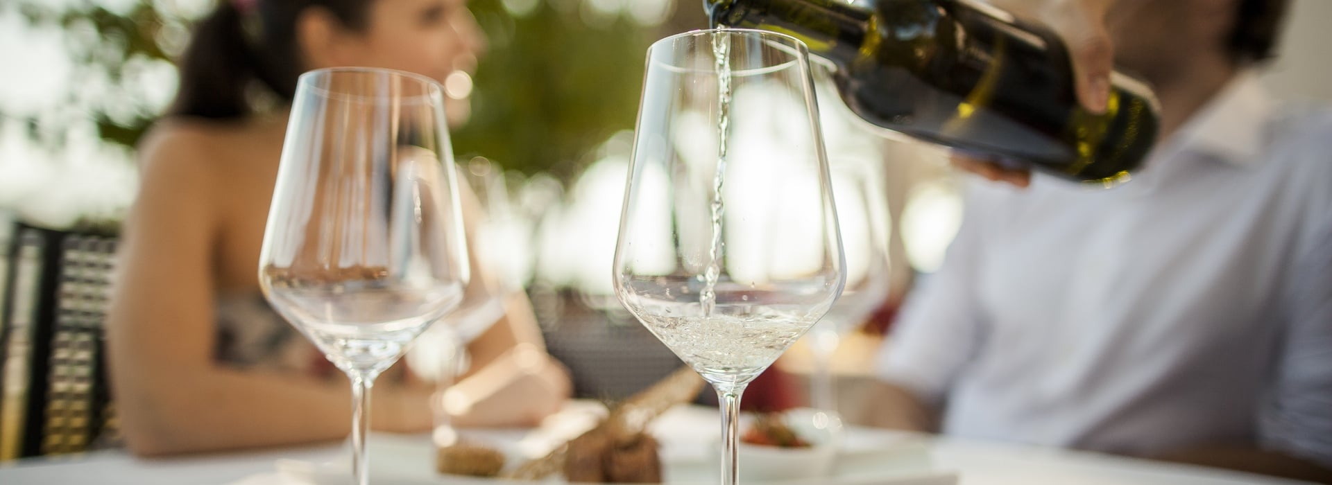 Weißwein wird professionell in Weingläsern serviert