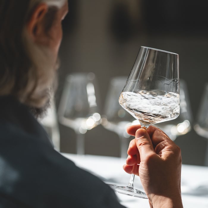 Ein Glas Weißwein wird sanft geschwenkt.
