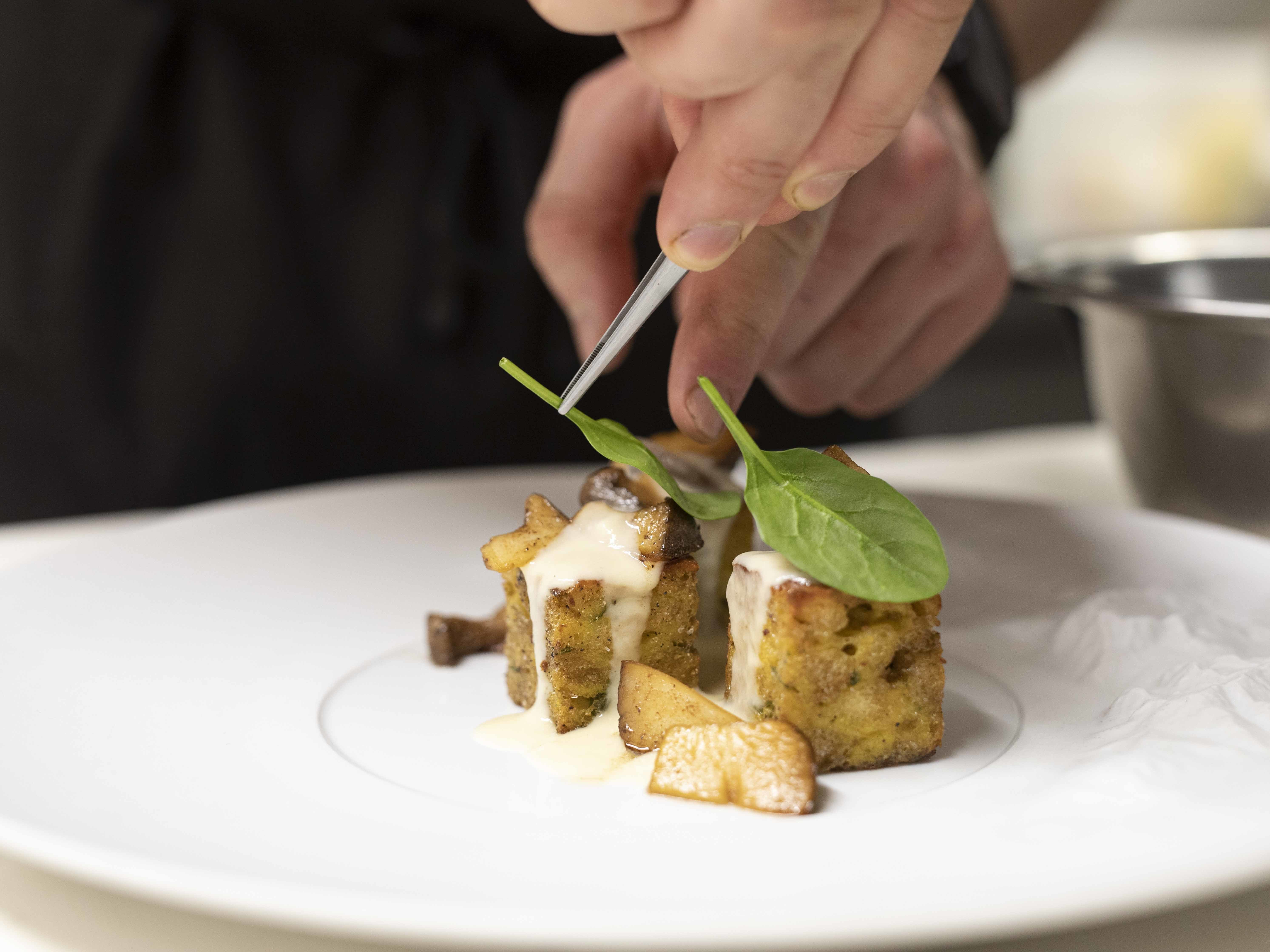 Der Kräuterknödel wird zusammen mit den Wirsingröllchen serviert. ©IDM/Südtirol Wein/Marion Lafogler