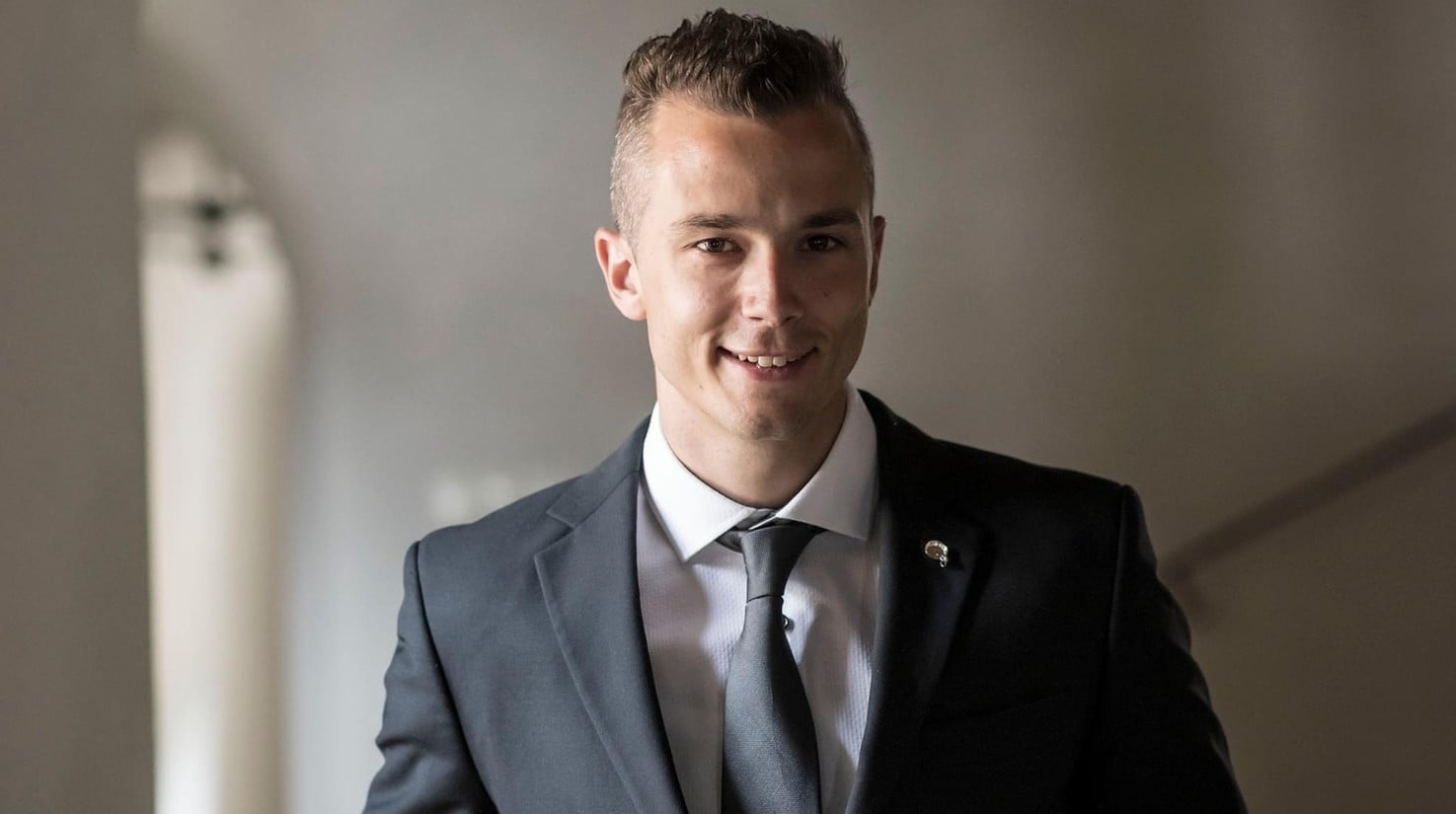 Portrait von Bastian Winkler, der mit eleganten Anzug lächelnd dargestellt wird.